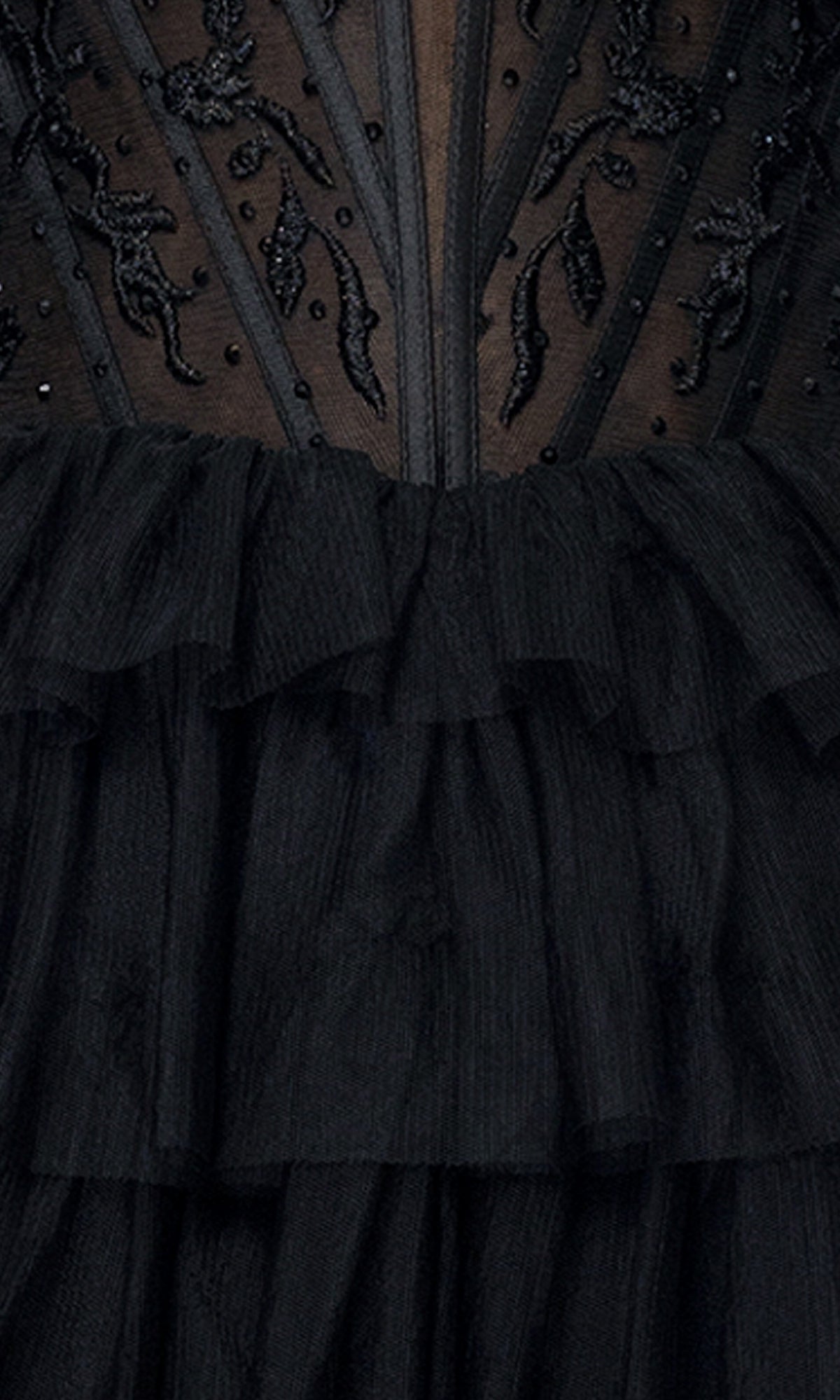 Close-up of the Long Black Ruffle Prom Dress Blondie Nites 5390BN, showcasing its off-the-shoulder sheer fabric, intricate beaded embroidery, and layered tulle ruffles.